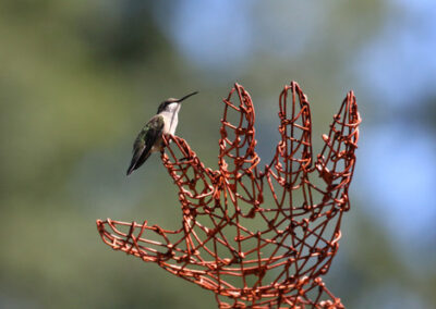 bird resting on hand sculpture